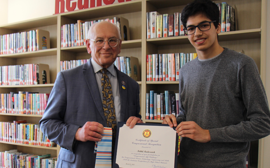 two people pose for photo with certificate and striped tie