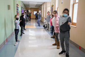 Picture of instructor leading class through movement exercise in hallway