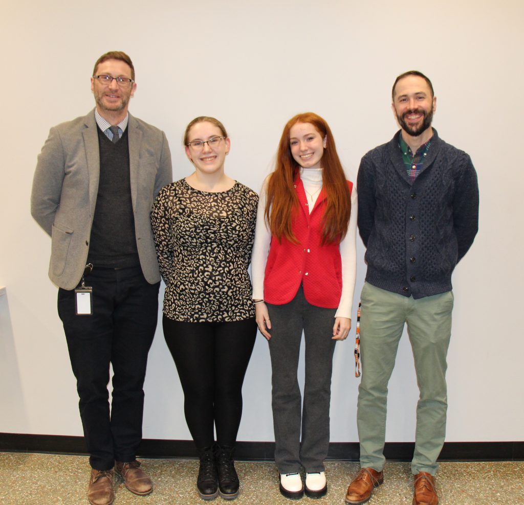 four people standing pose for photo