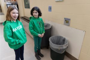 Students Grace Leddy and Matilda Sugar stand by the composting area in Elsmere lunch room