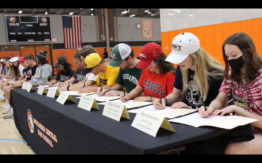 students signing piece of paper