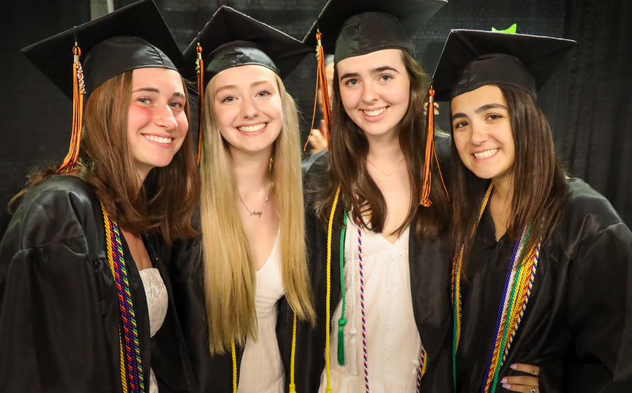 four students in caps and gowns