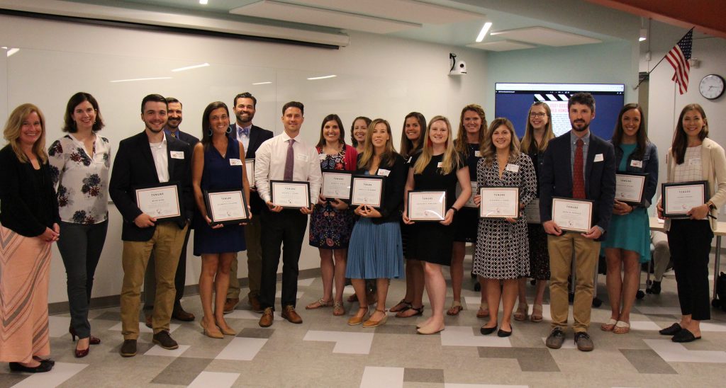 group of adults holding certificates