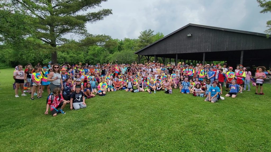 group of students pose in front of park pavilion