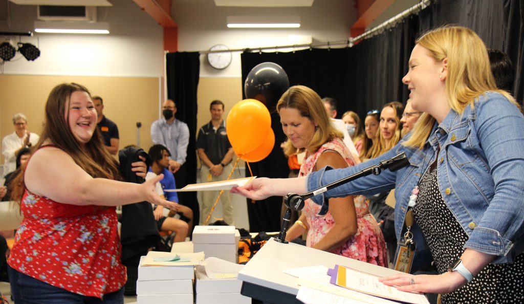 student smiles while receiving award