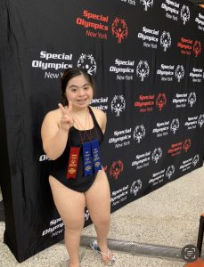 student in swim tank makes peace sign