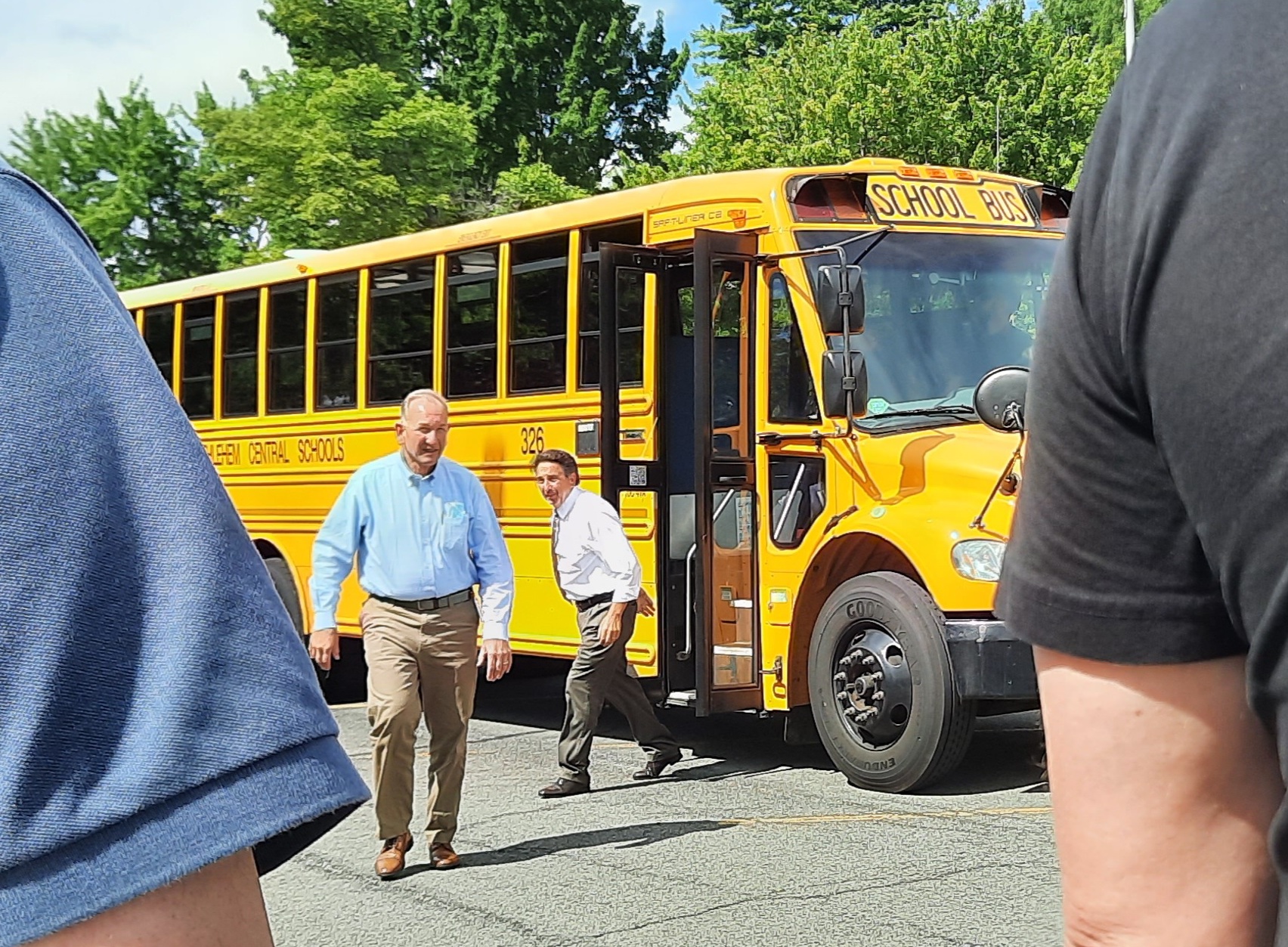 two people getting off school bus