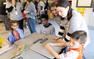 Members of BC Barkery sit at desks with elementary students to speak with them about what the BC Barkery does.