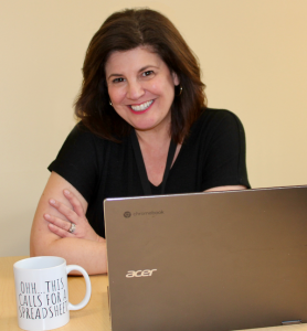 person sits at desk with arms folded.