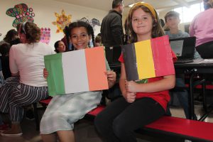 two students holding flags and smiling