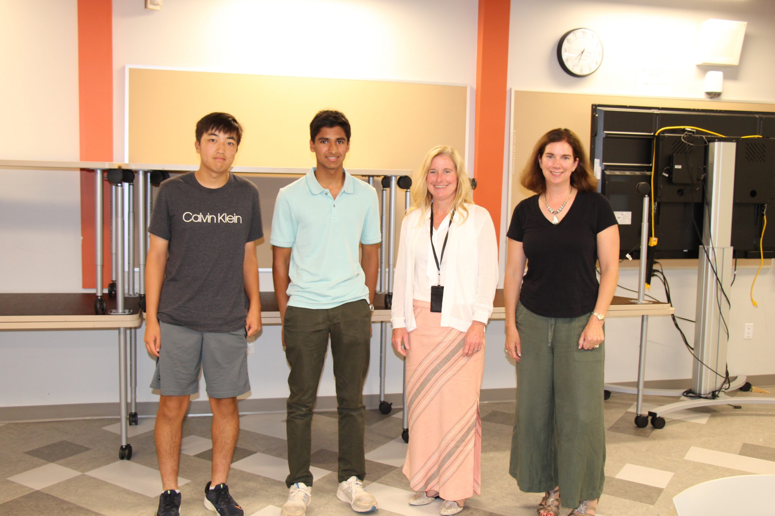 Ian Jin and Aadi Ojha pose with Superintendent Jody Monroe and Board President Holly Dellenbaugh.