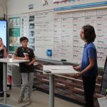 four students standing at front of classroom