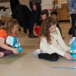 students holding blue robots
