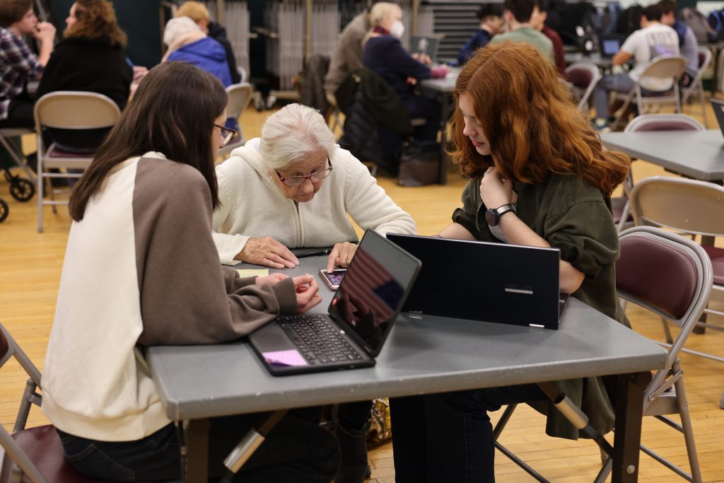 area resident shows two students a smartphone