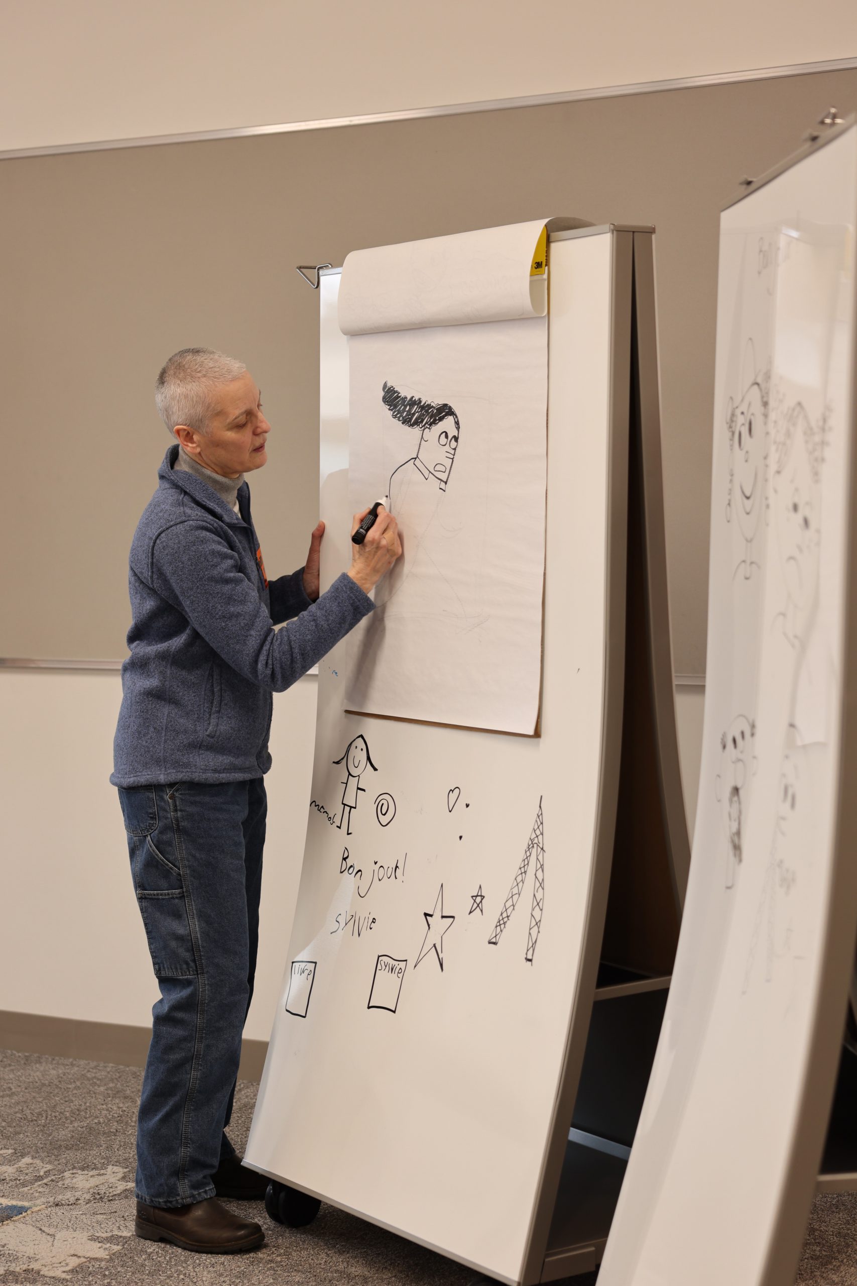 Sylvie Kantorovitz demonstrates elements of illustration on a white board.