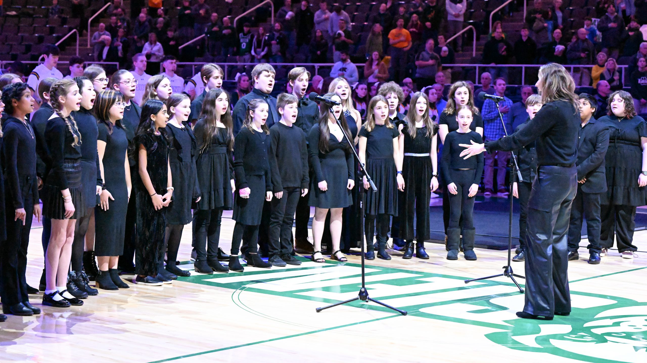 students dressed in black singing
