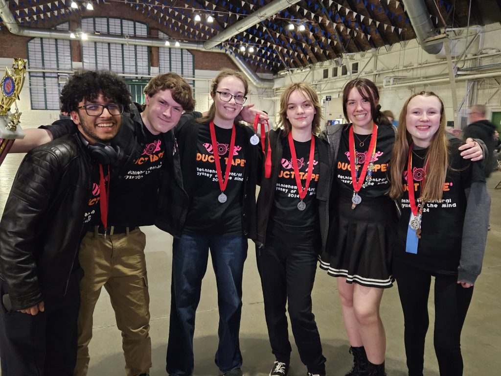 students wearing medals and smiling