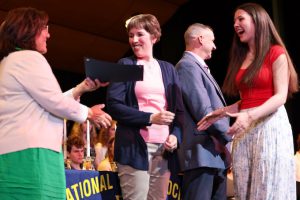 student smiles while being handed certificate