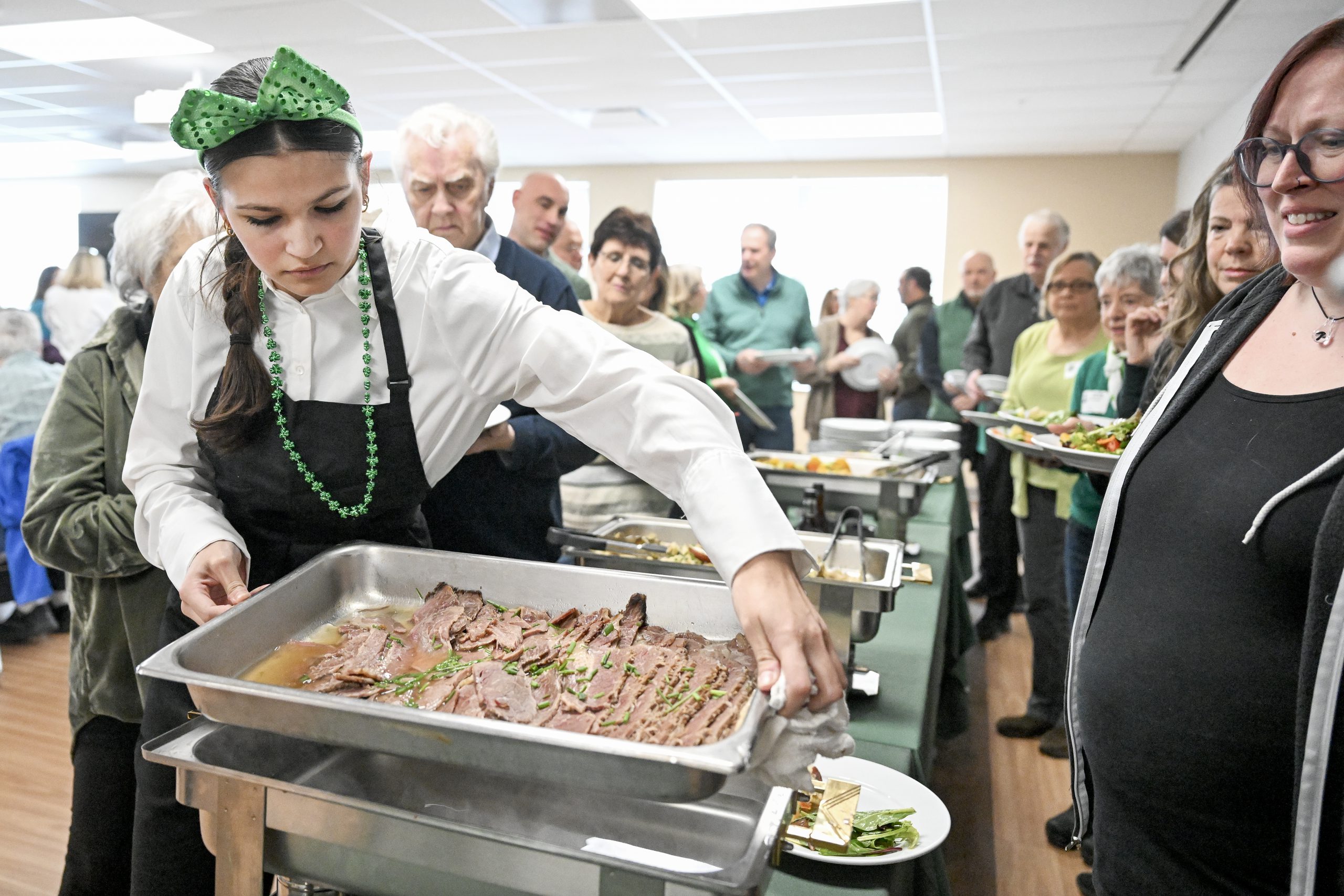 student sets up tray of food at St. Patrick's Day festival