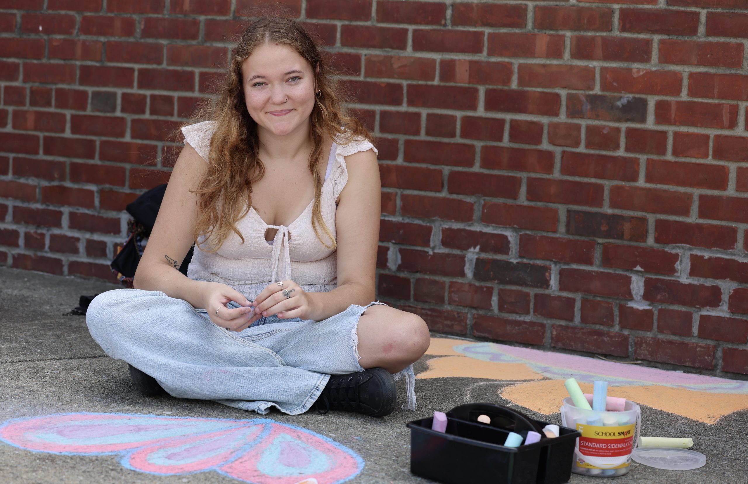 student working on sidewalk chalk art