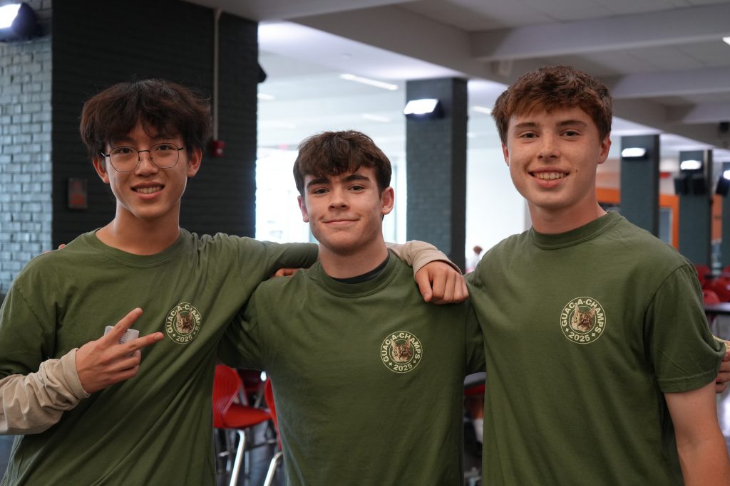 three students in green tshirts