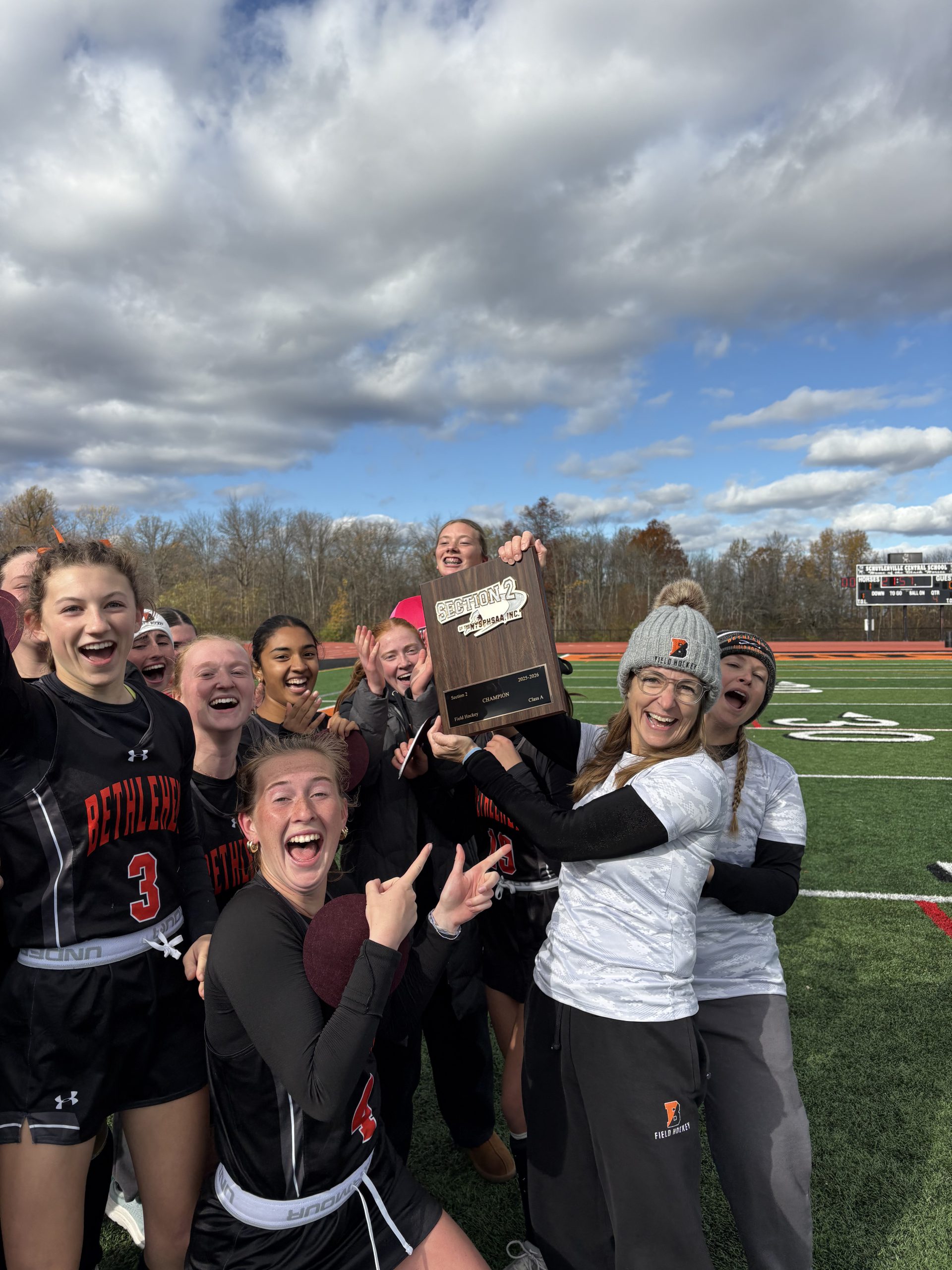 Image of field hockey team members celebrating their win.