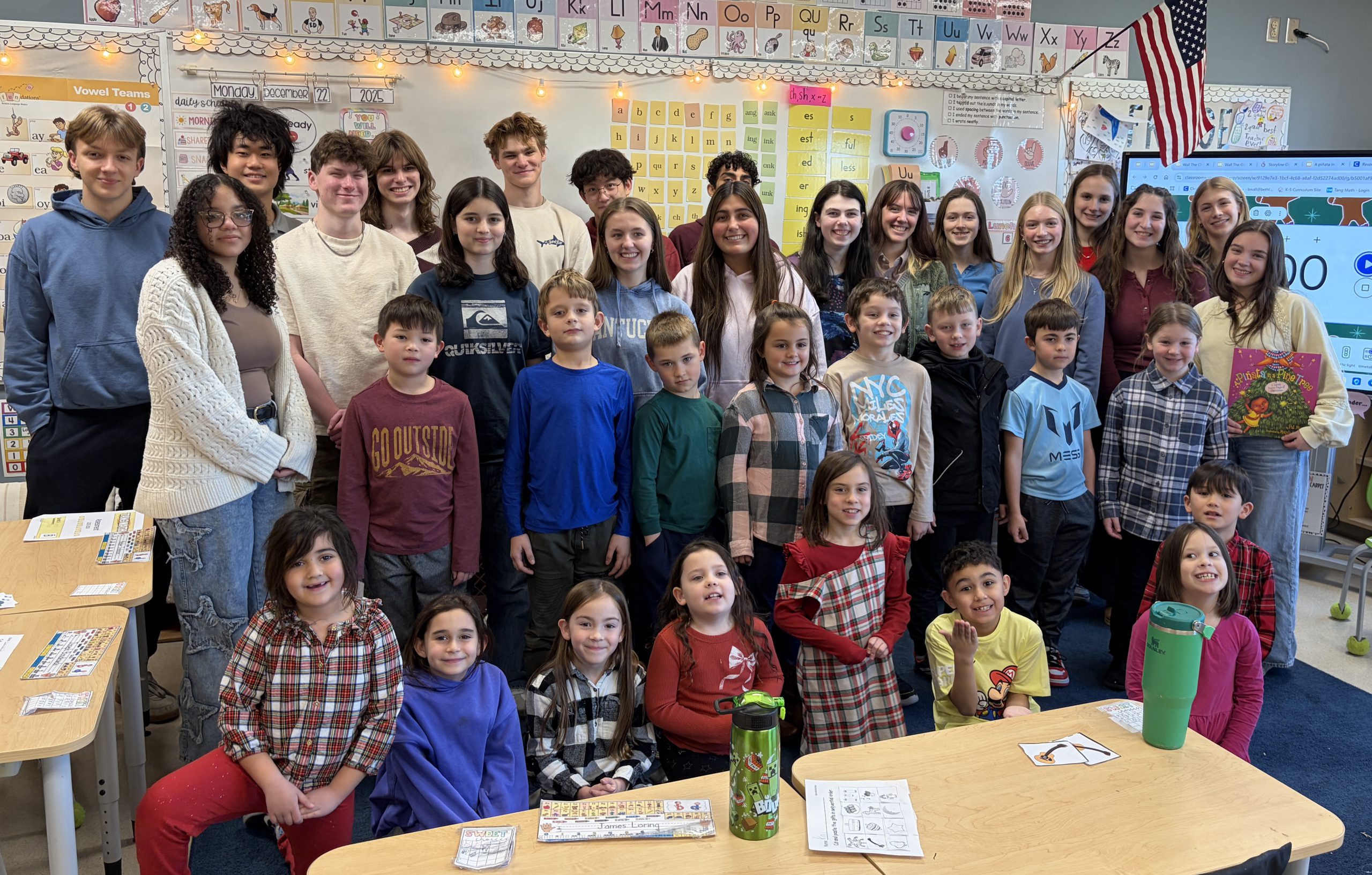 group of second graders and high school students pose for photo