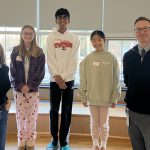 five people pose for photo