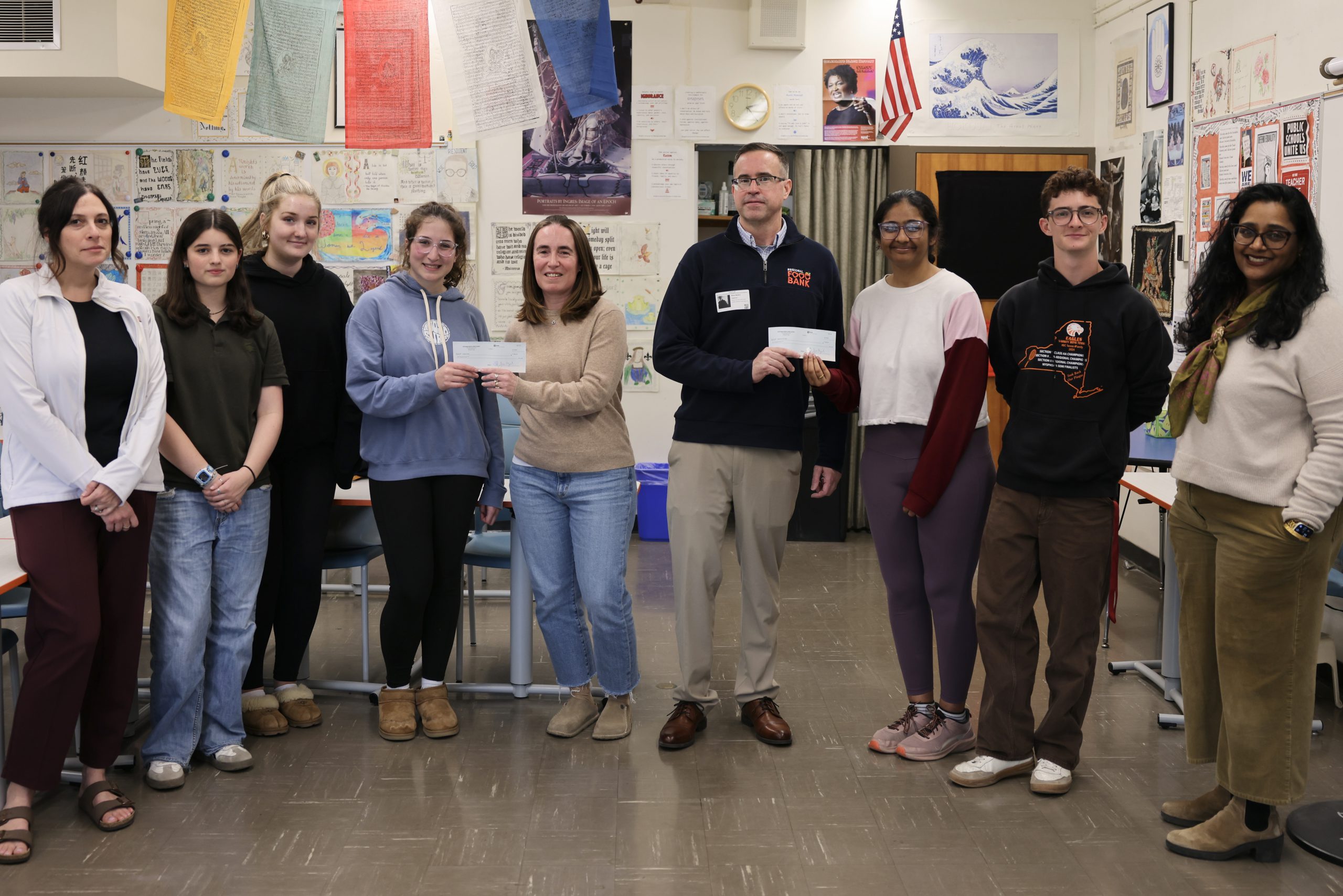 group of people pose for photo holding checks