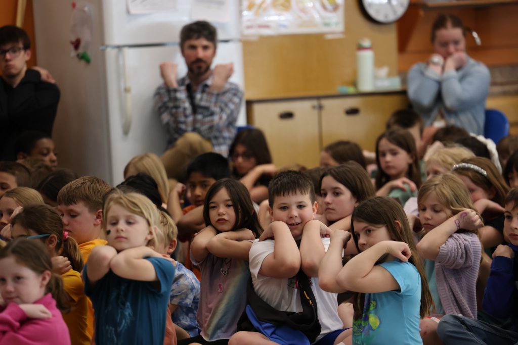 students putting their elbows together