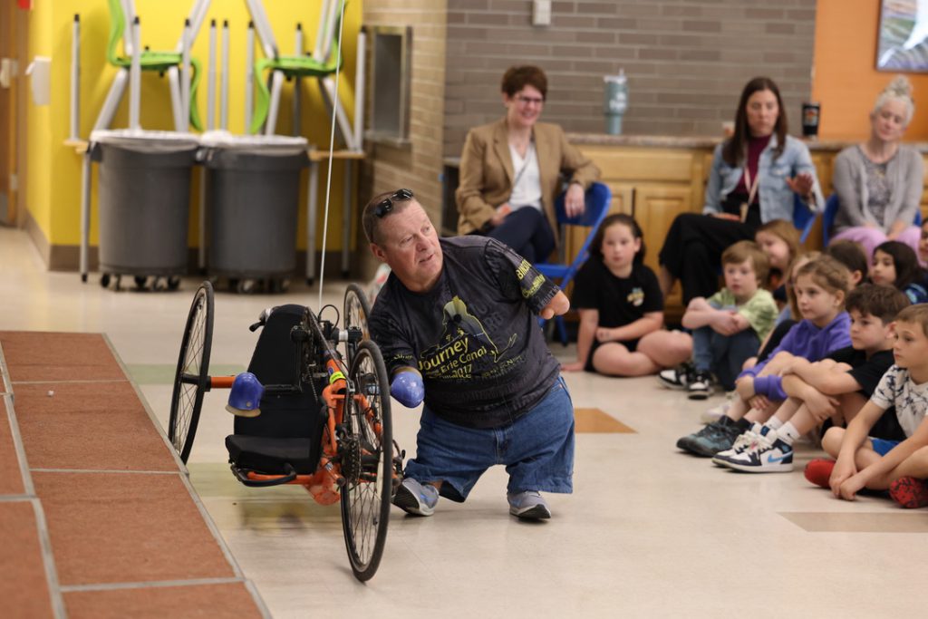 person uses hand pedals on tricyle