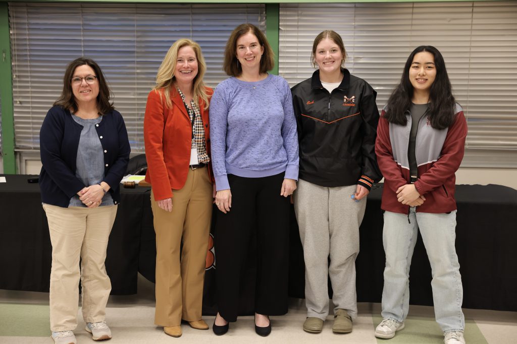 five people pose for photo