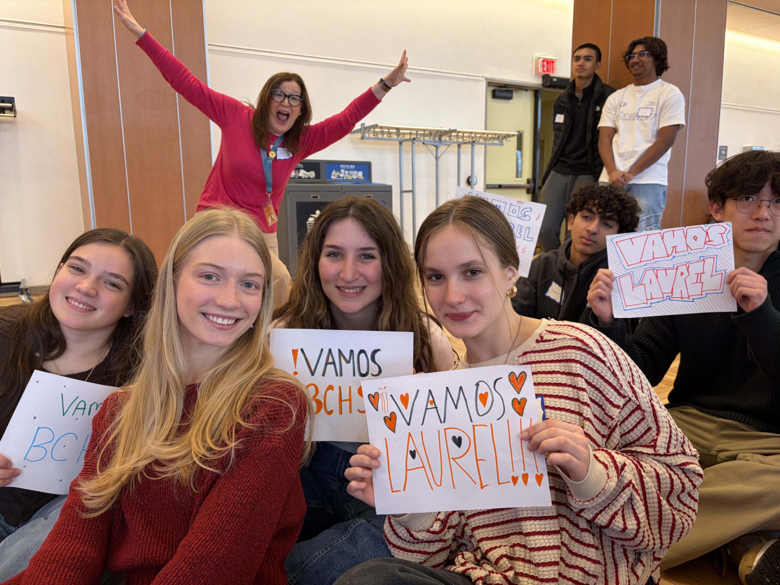 students pose for photo while being photobombed by teacher