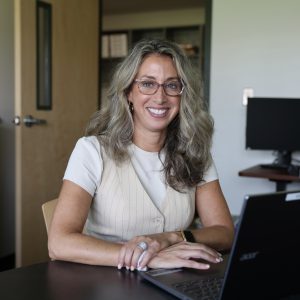 person sitting at table with hands folded