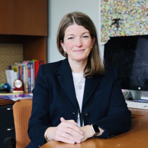 person sitting at desk with hands folded
