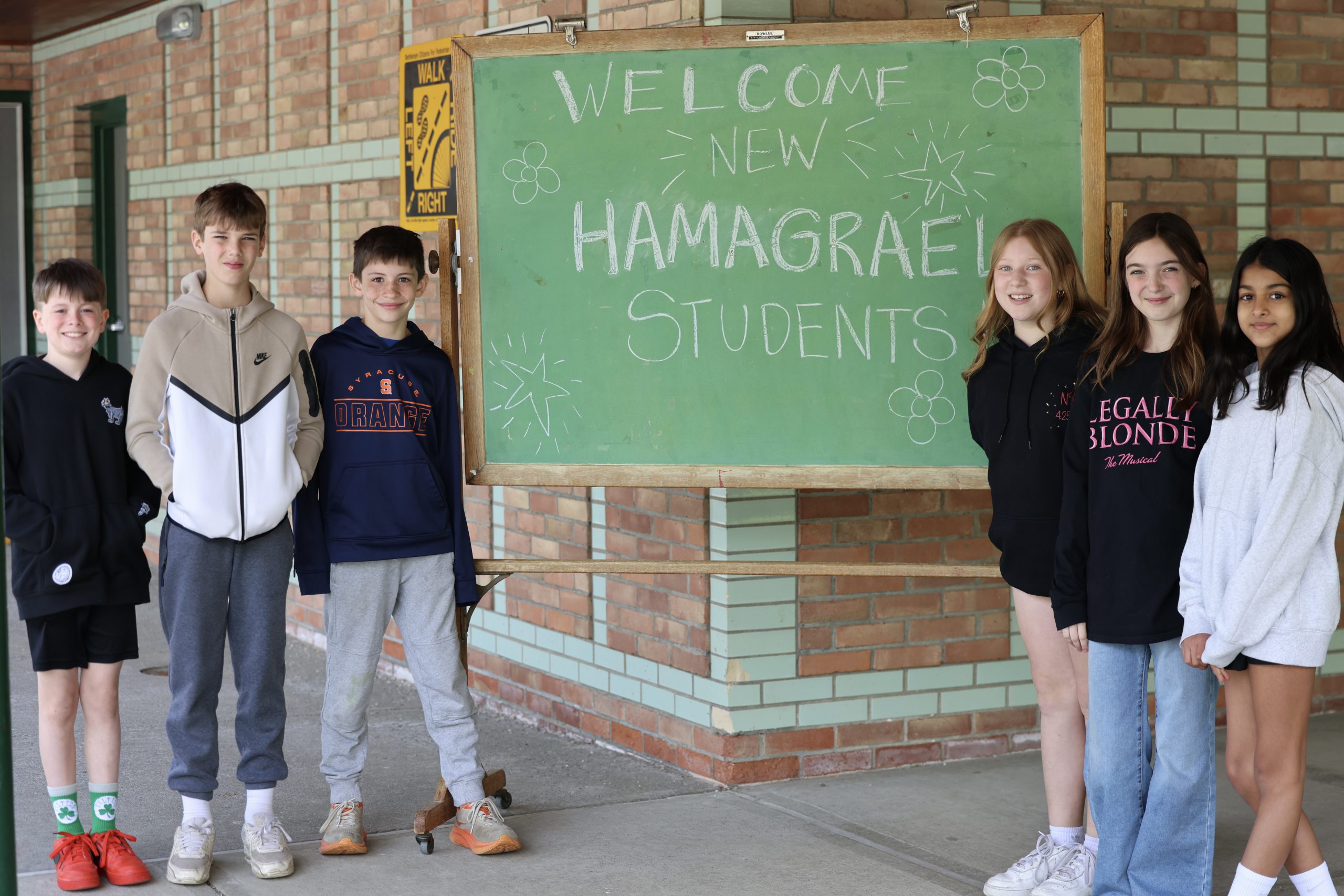six students stand near chalkboard