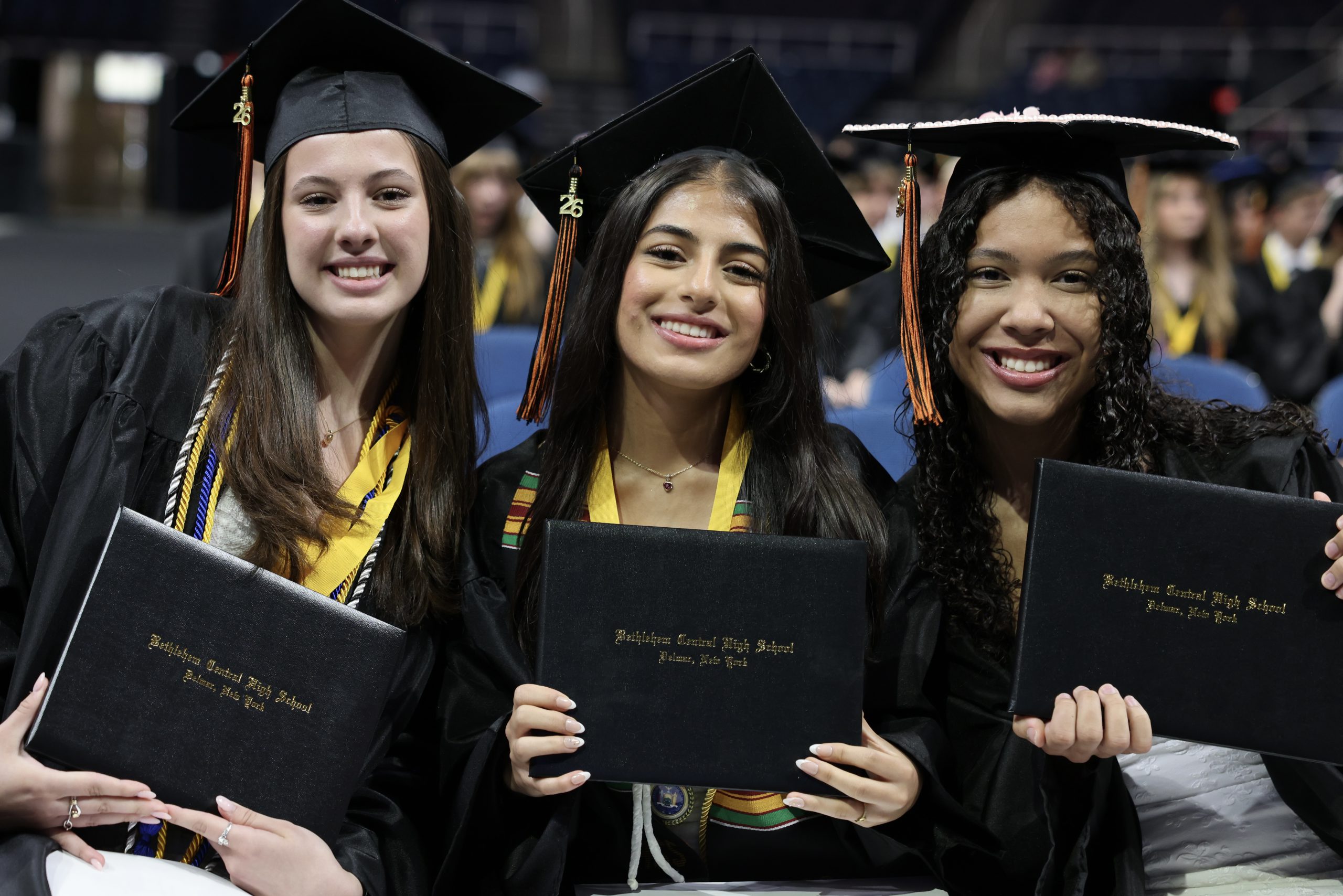three students with diplomas