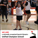 student with arms up in the air in celebration