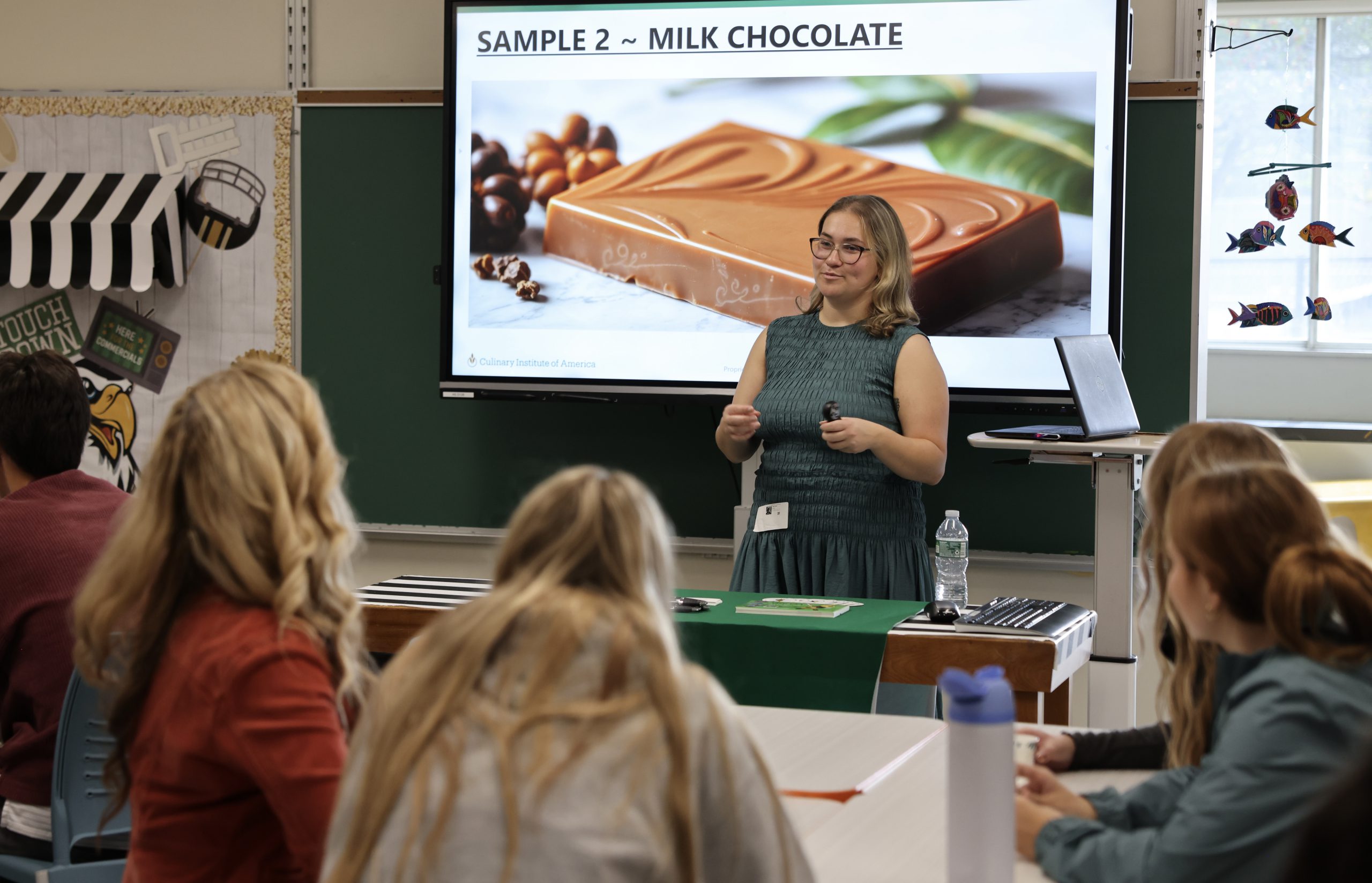 person speaks to class with photo of chocolate bar in background